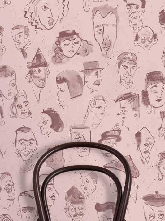 A repeating pattern of hand-drawn caricature faces in dark brown ink on a dusty pink background.