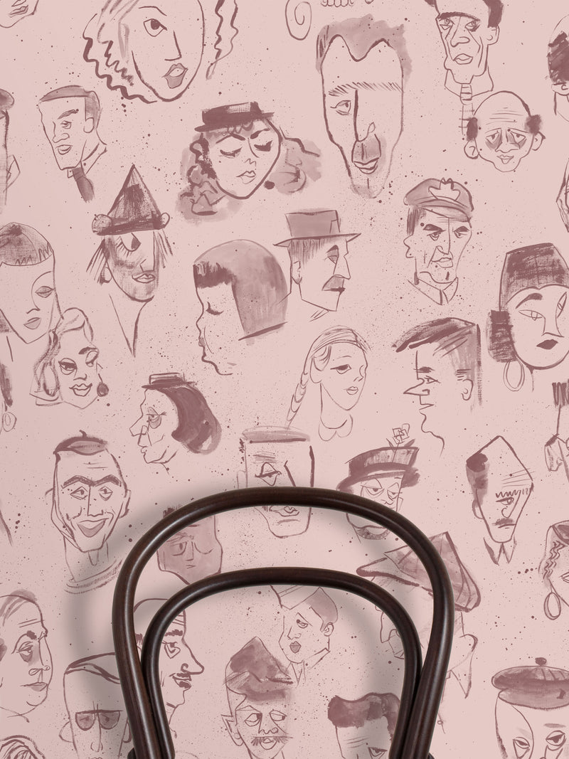 A repeating pattern of hand-drawn caricature faces in dark brown ink on a dusty pink background.