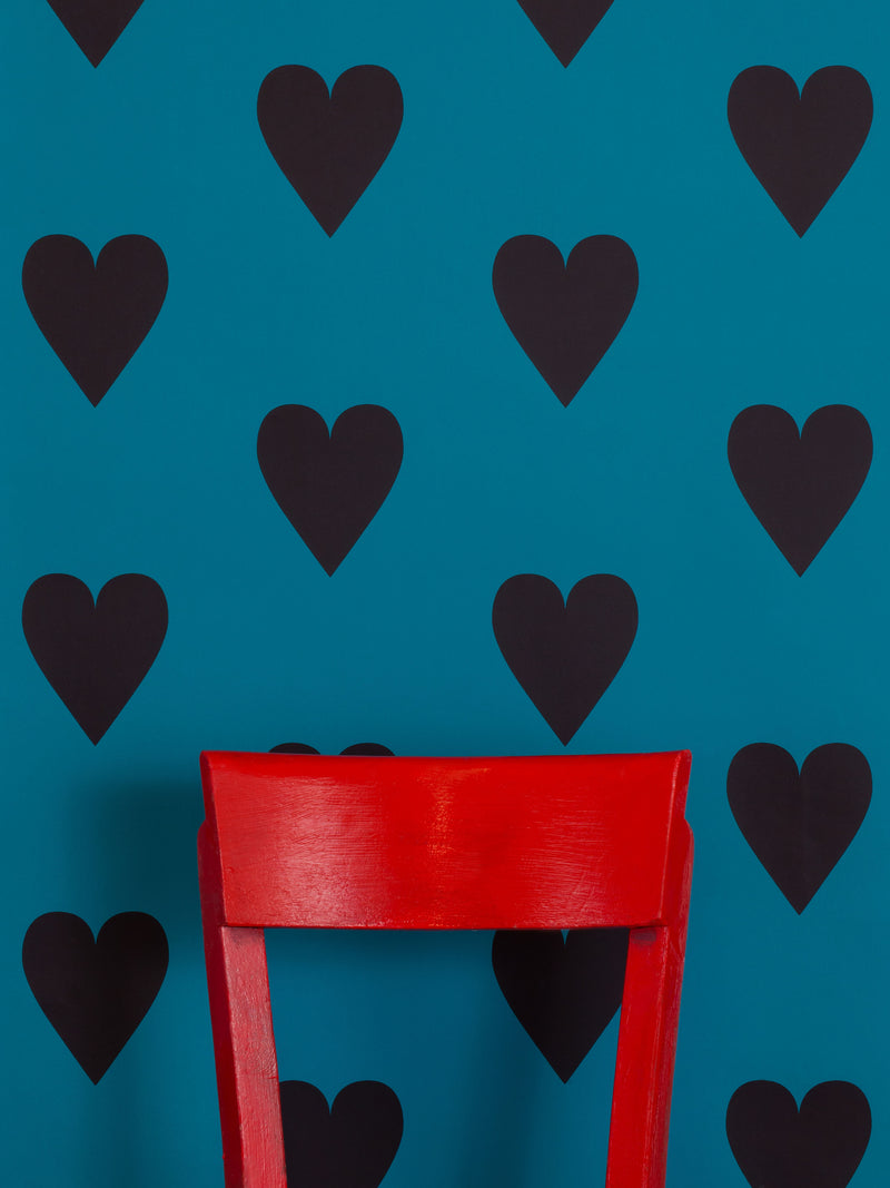 Hand screen printed wallpaper featuring black hearts on a blue background.