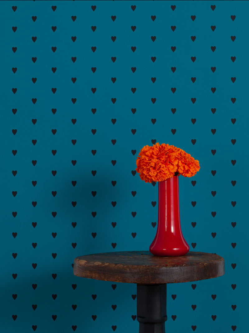 Hand screen printed wallpaper featuring black hearts on a blue background.